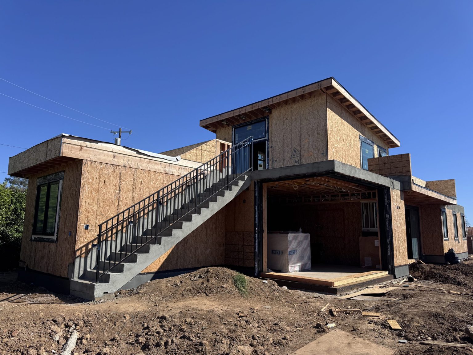 Two-story DVLP home under construction in Los Angeles with sheathed framing, poured concrete stairs, and new windows